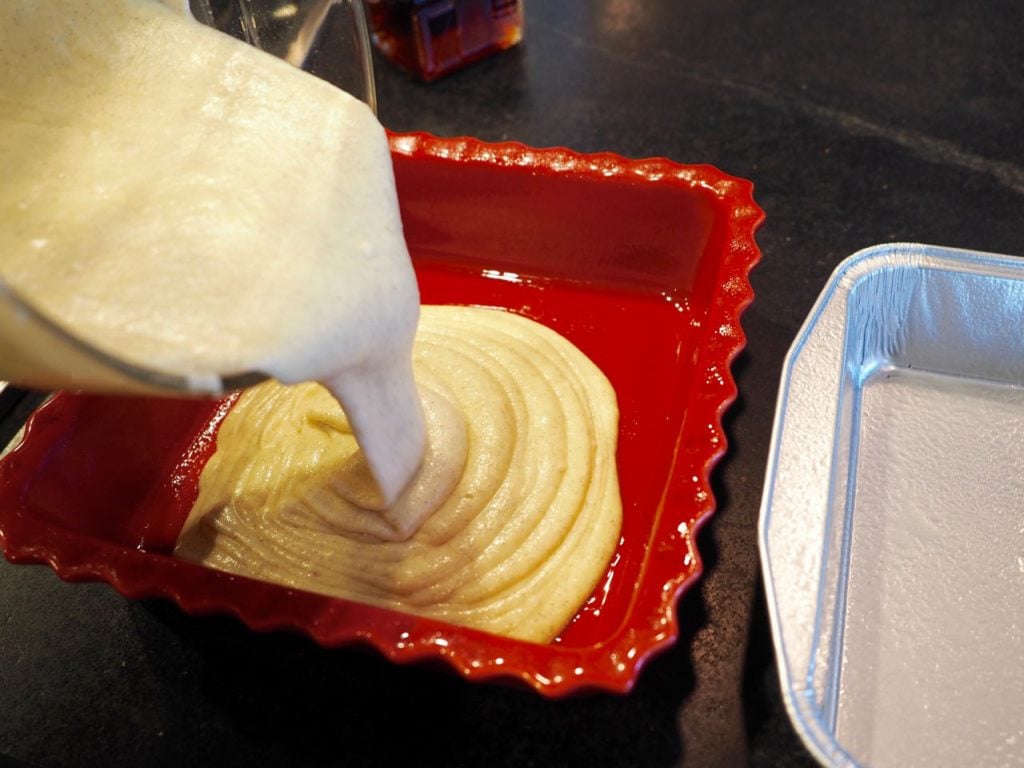 Pouring Starbucks coffee cake batter into prepared pans.