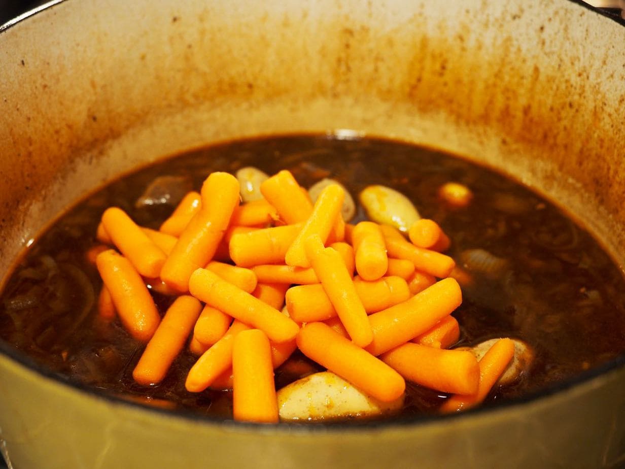 Adding carrots and potatoes to beer beef stew. 