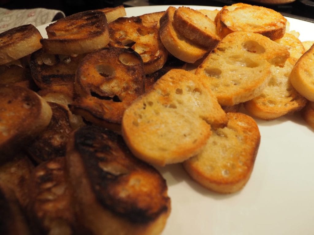 Plate full of toasted crostini slices (sliced french baguette)