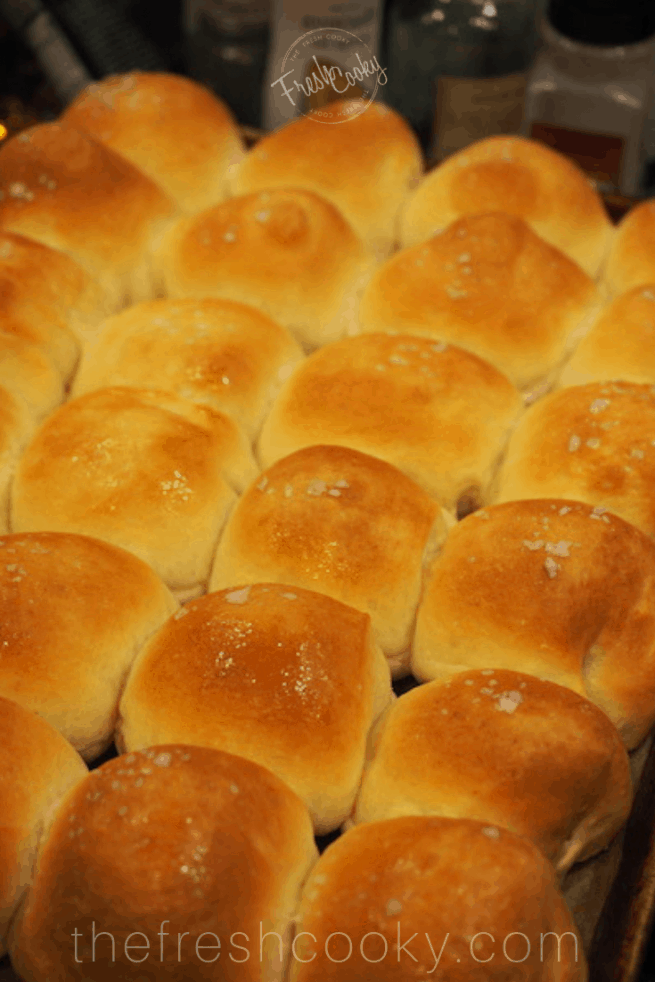 cookie sheet with golden, buttery easy yeast rolls with a sprinkle of sea salt on top!