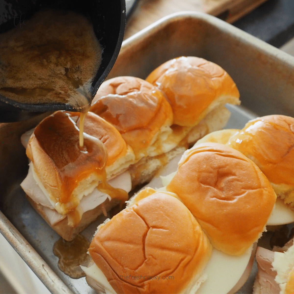 Square image of pouring marinade sauce over funeral sandwiches.