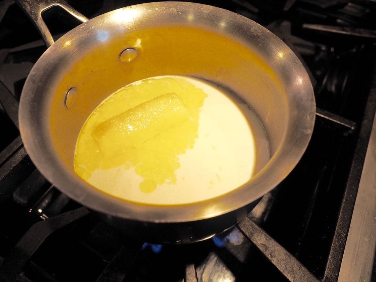 Melting butter and scalding milk in saucepan for homemade cinnamon rolls.