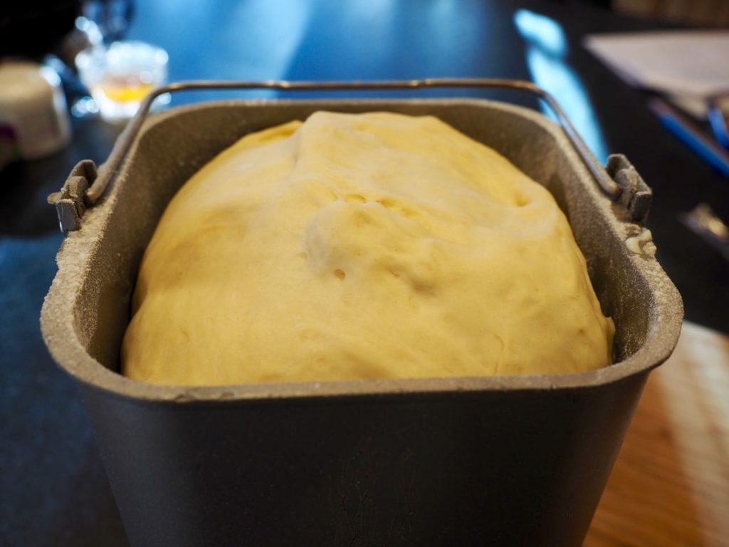 Risen dough to the top of the bread machine bread pan. 