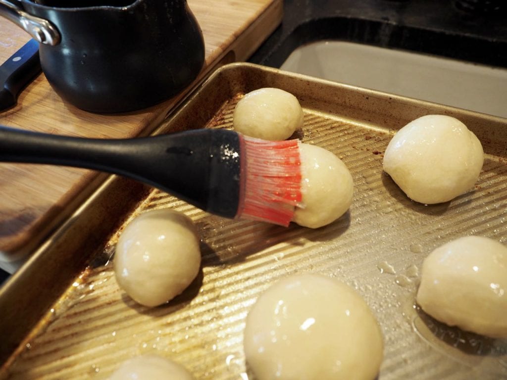 Brushing tops of rolls with melted butter