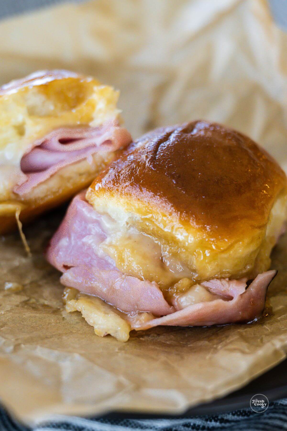 Ham and cheese sliders on parchment paper.