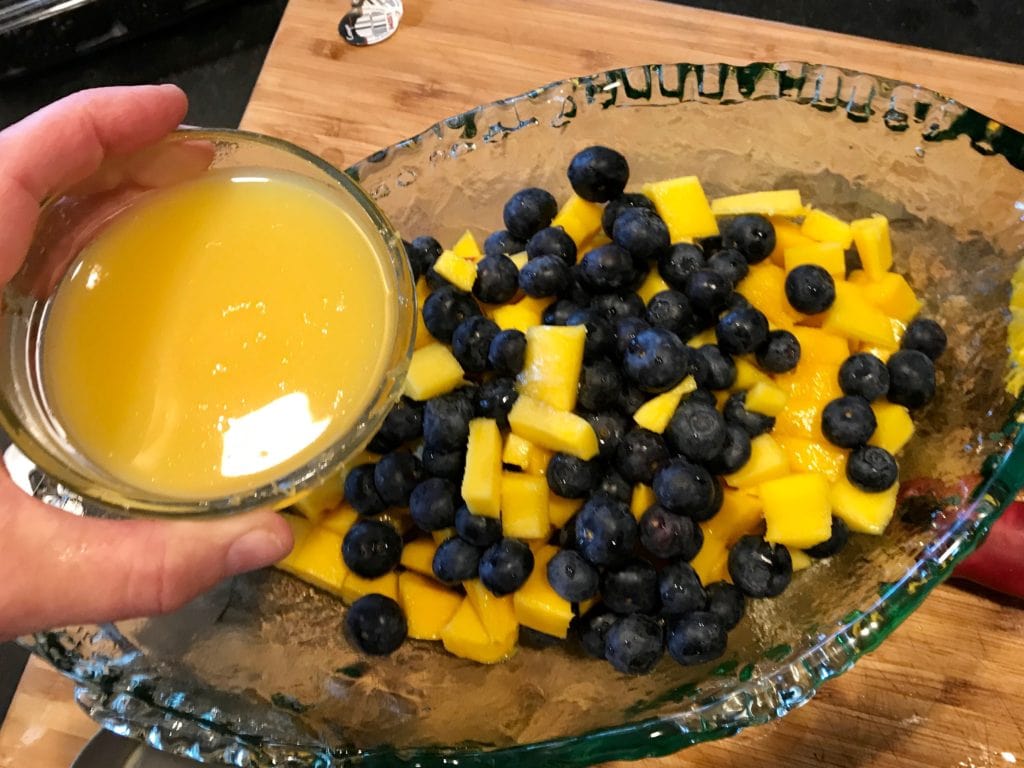 Pouring juice and honey mixture over fresh fruit | www.thefreshcooky.com