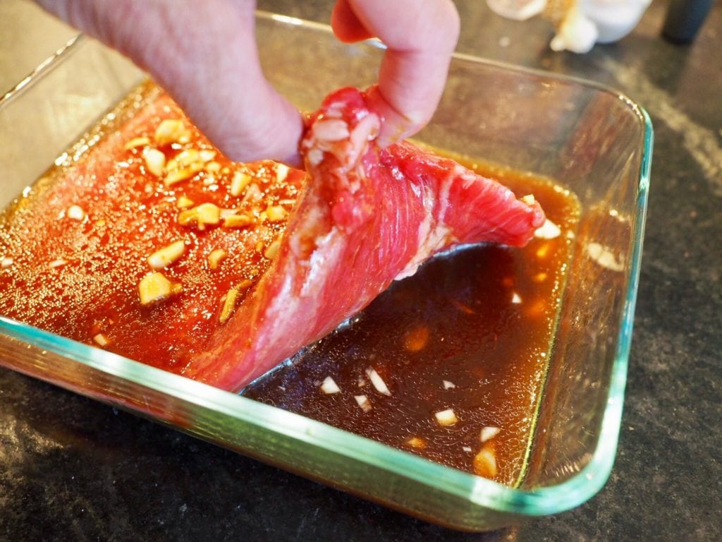 LIFTING UP FLANK STEAK TO ALLOW MARINADE TO COME ALL THE WAY THROUGH | www.thefreshcooky.com