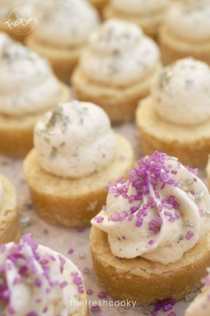 Pinterest Pin with sugar cookie bites frosted with little kisses of frosting and sprinkled with purple and silver sugars. 