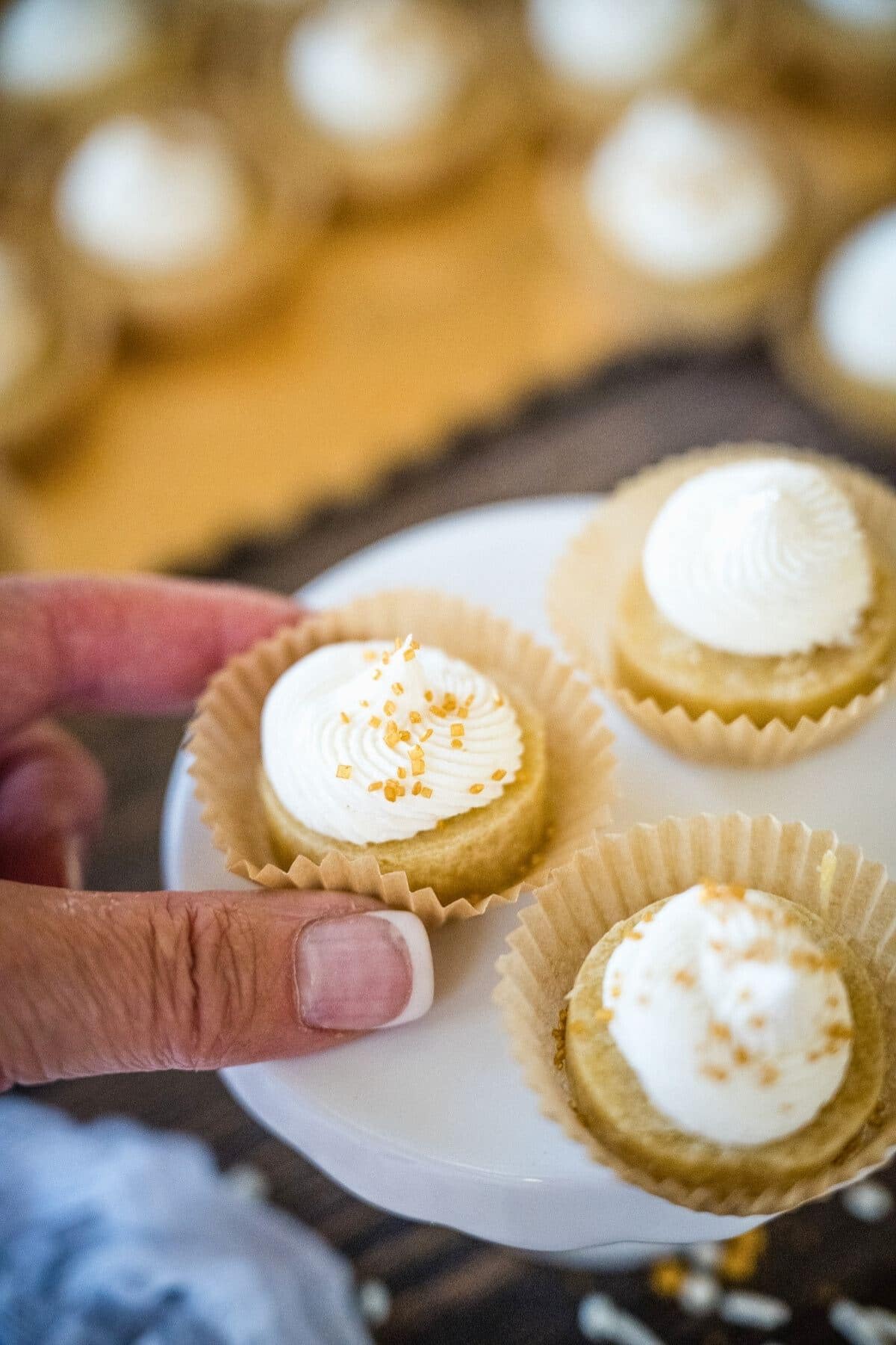 Hand grabbing a sugar cookie bite with frosting. 