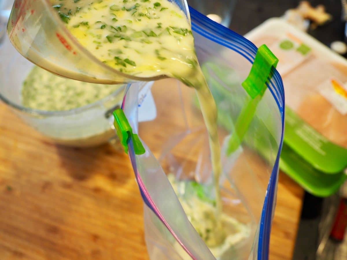 Pouring coconut lime marinade into baggie.