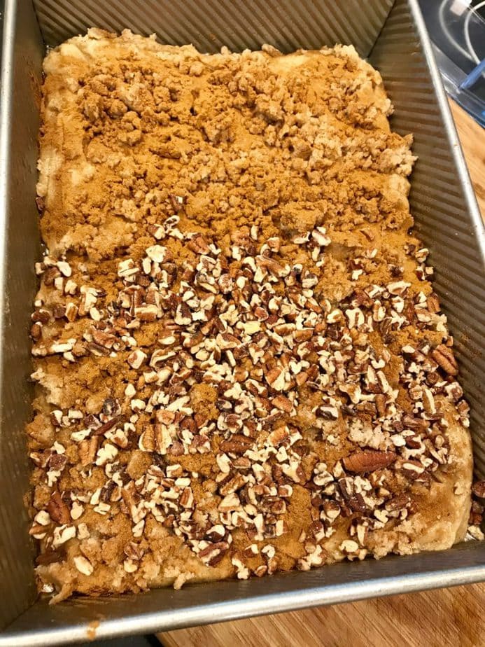 Crumbs spread on top with half covered in chopped pecans for Gluten Free Coffee Cake | www.thefreshcooky.com