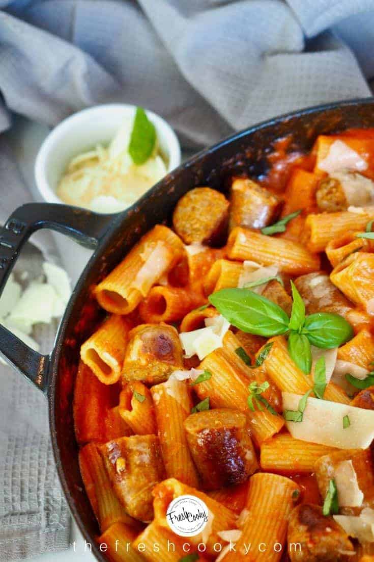 Large pan filled with creamy penne alla vodka pasta with Italian sausage, shaved Parmesan and fresh basil.