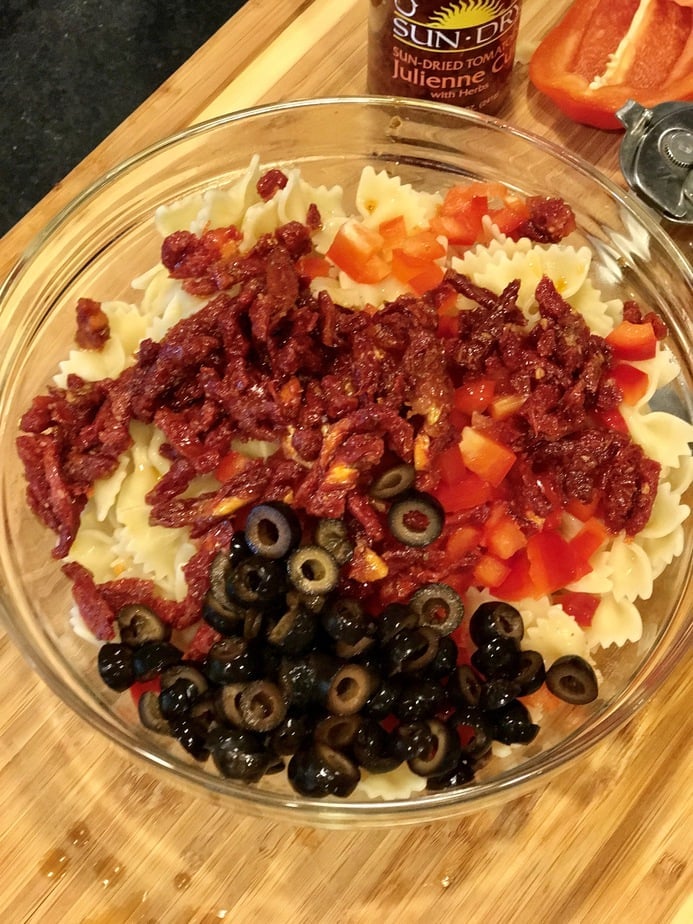 Sliced black olives on top of pasta salad. 