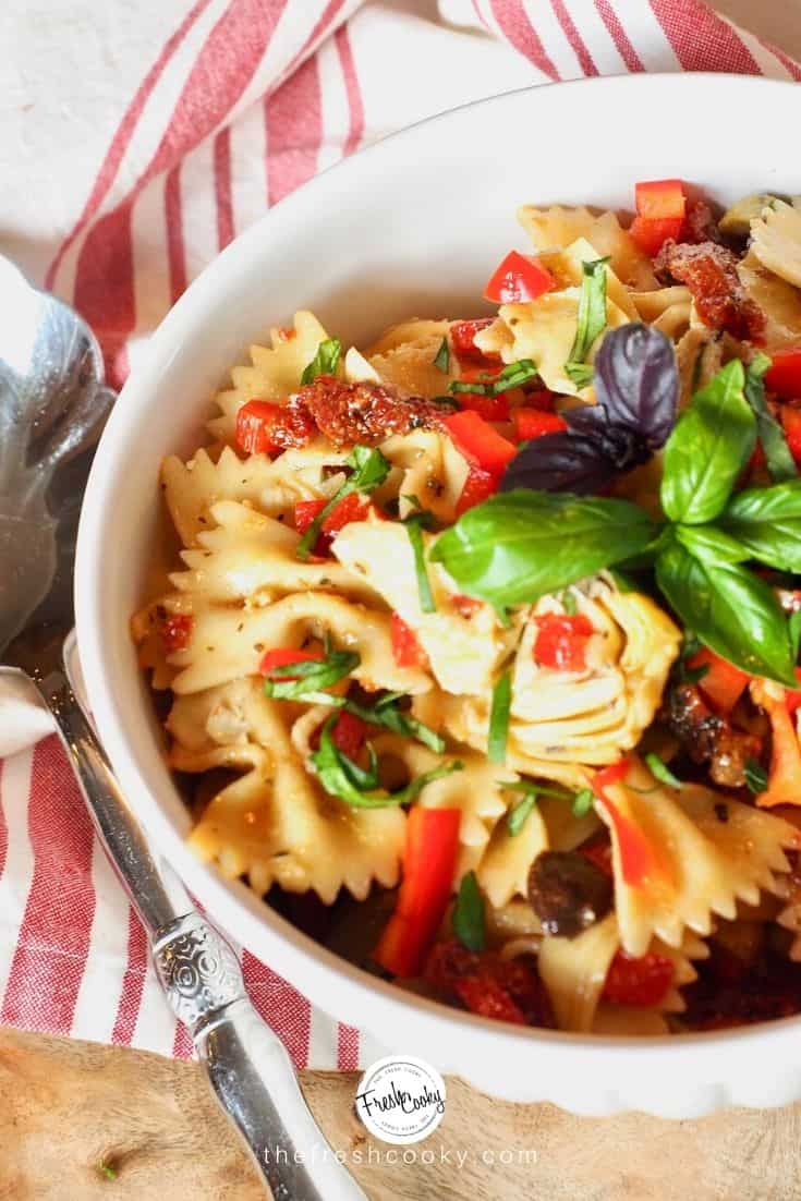 white bowl filled with colorful Italian Pasta salad with bowtie pasta. 