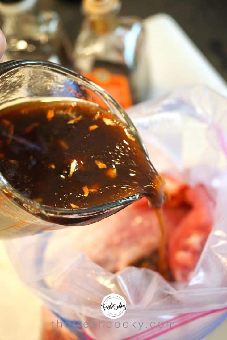 Pouring marinade over pork tenderloin (in baggie)