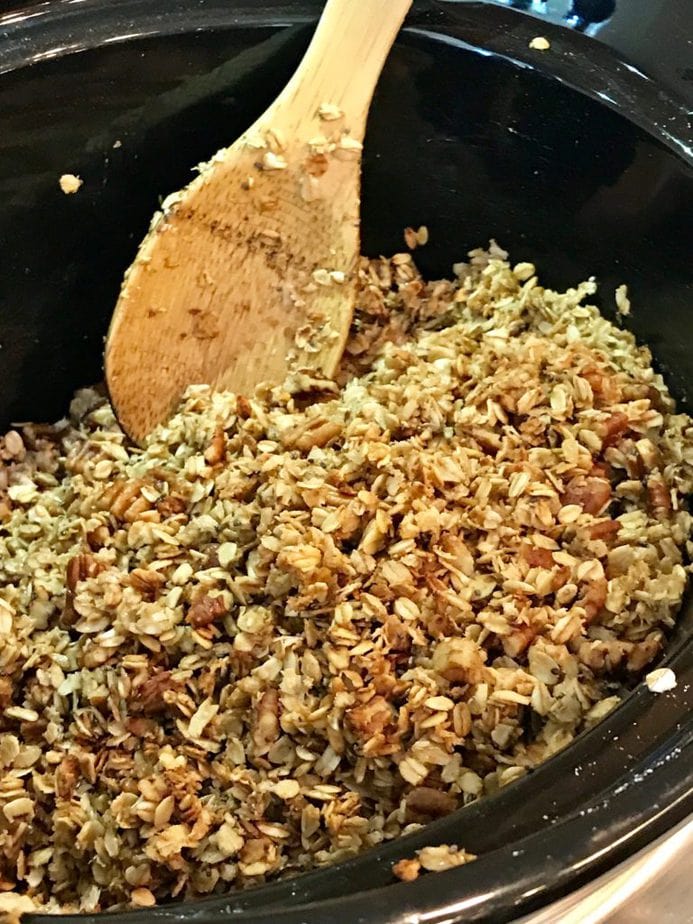 Stirring the granola every 15 minutes, wooden spoon in crockpot. 