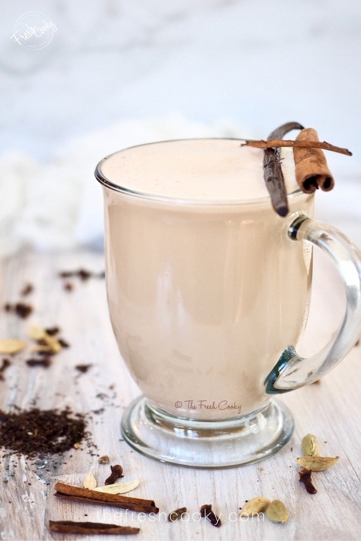 Chai latte in glass mug with cinnamon and vanilla.
