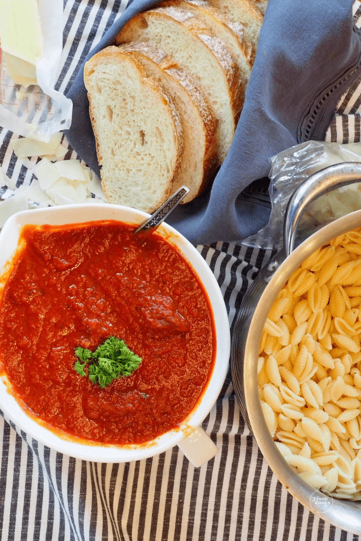 Bowl of thick authentic spaghetti sauce with pasta and sliced Italian bread.