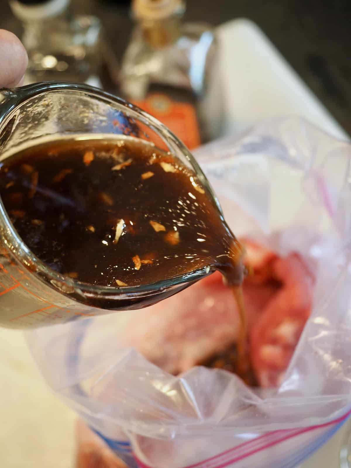 Pouring Marinade onto Pork tenderloin for asian marinade. 