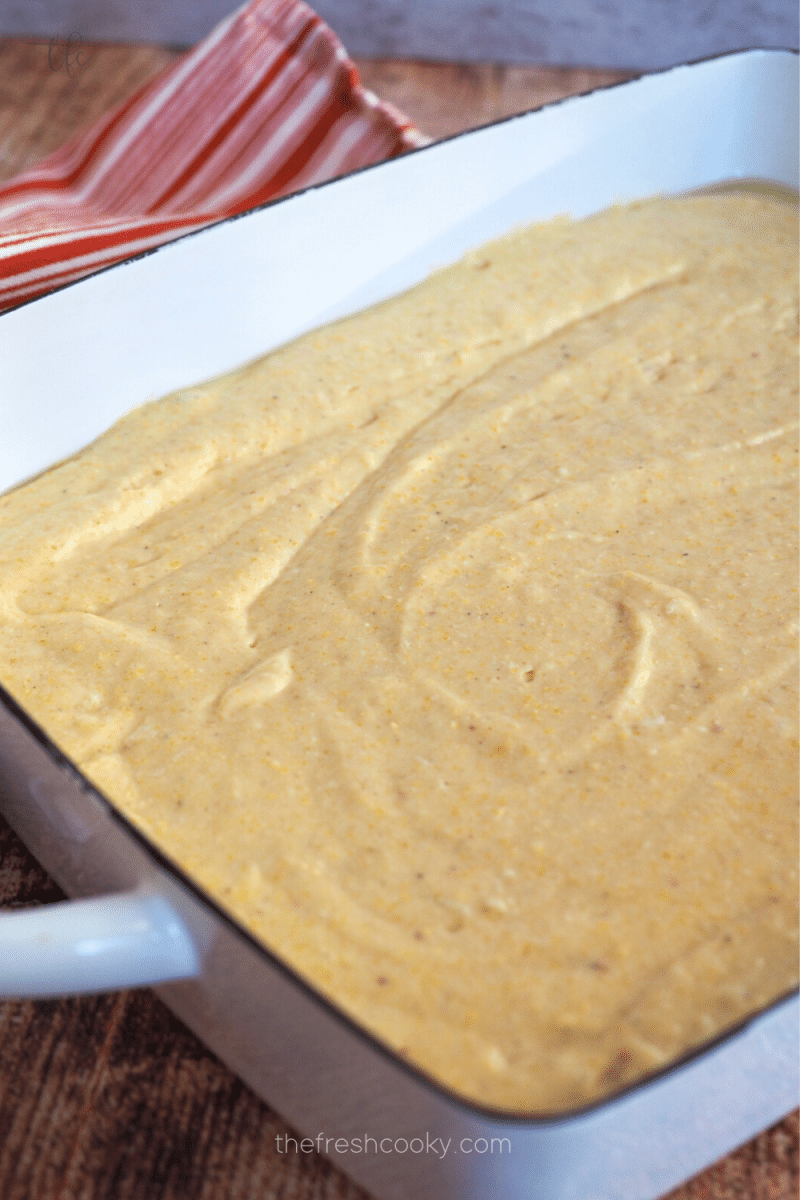 Sweet cornbread batter poured into pan and smoothed ready for oven. 