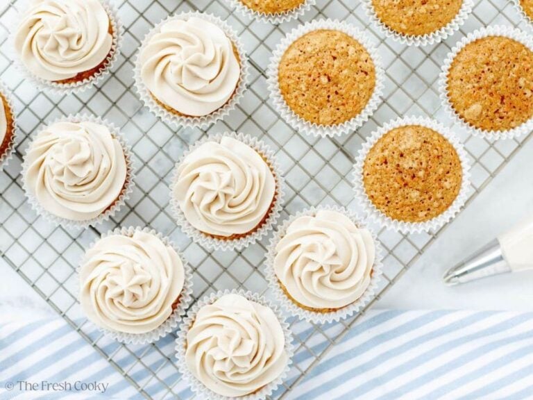 Carrot cake cupcakes some frosted and some naked, on wire rack.