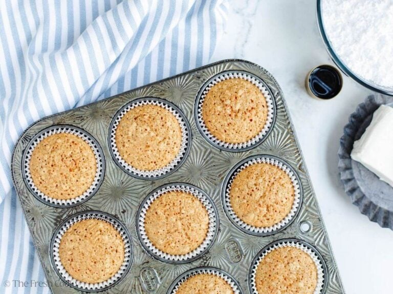 Baked carrot cake cupcakes in muffin tin, cooling. 