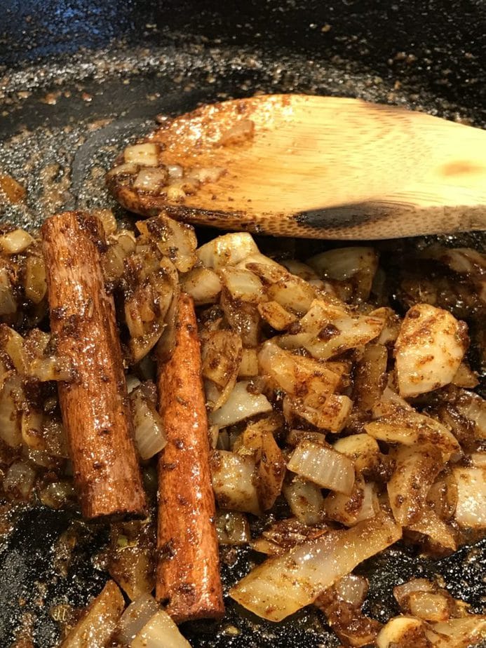 adding cinnamon sticks in pan with onions for best chili recipe ever.