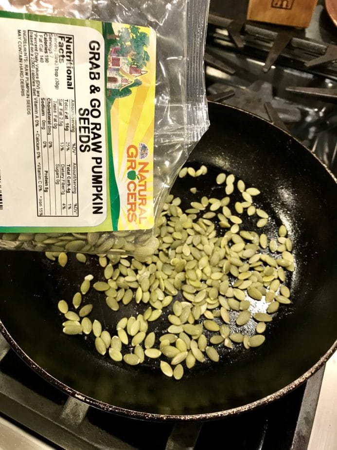 Pouring pumpkin seeds in to fry pan from plastic bag of Pumpkin Seeds