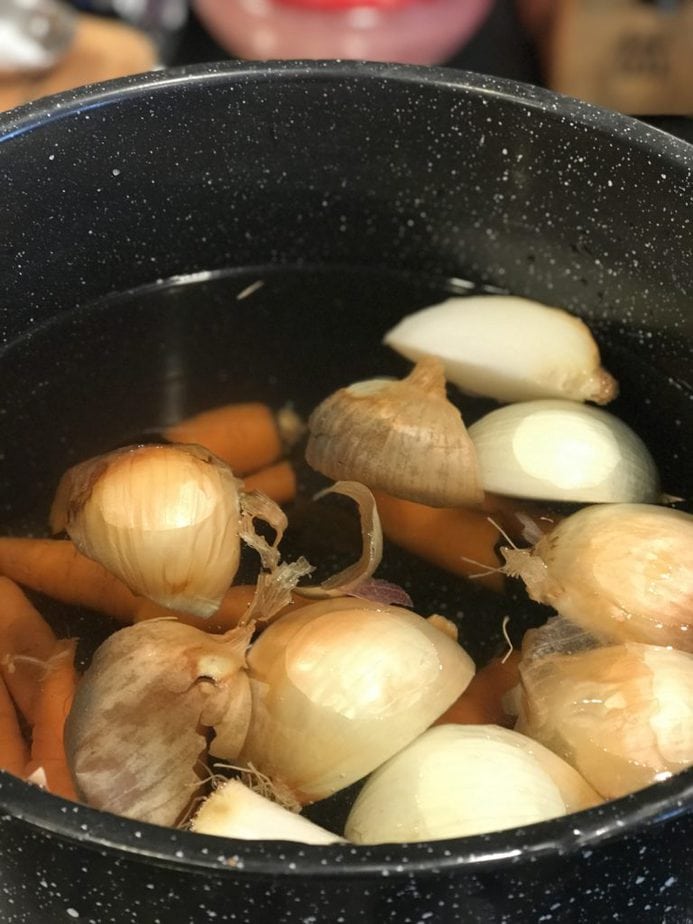 large pot with rough chopped onions, carrots and filled with water