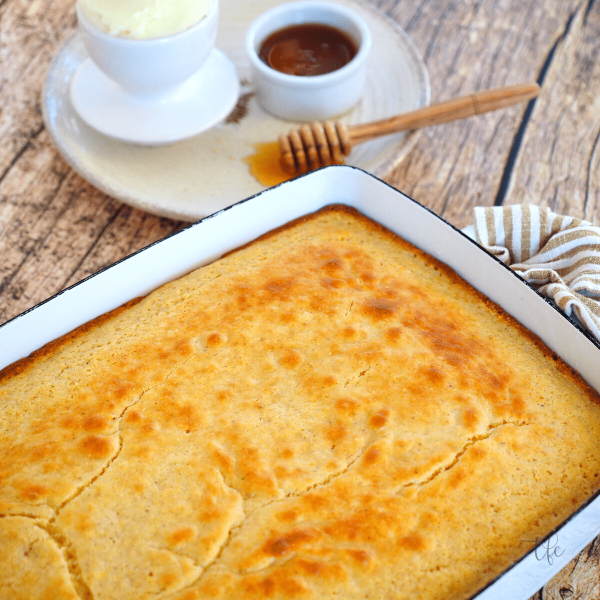Square image of pan of warm, sweet southern cornbread with honey and butter.
