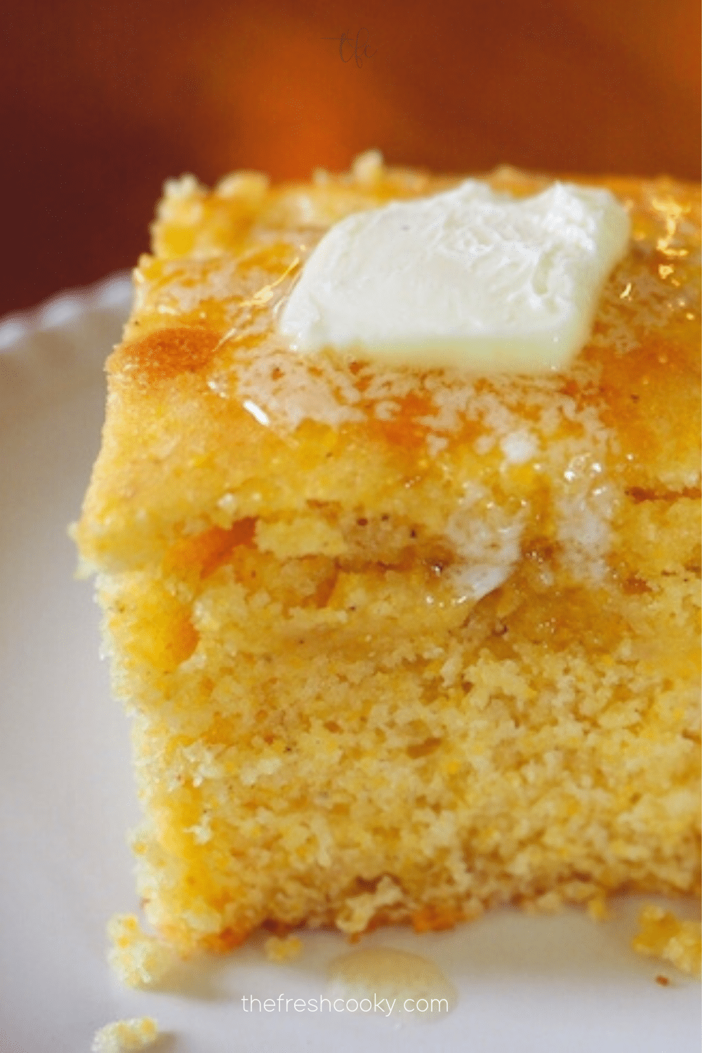 Best sweet cornbread recipe with square on a plate with melting butter.