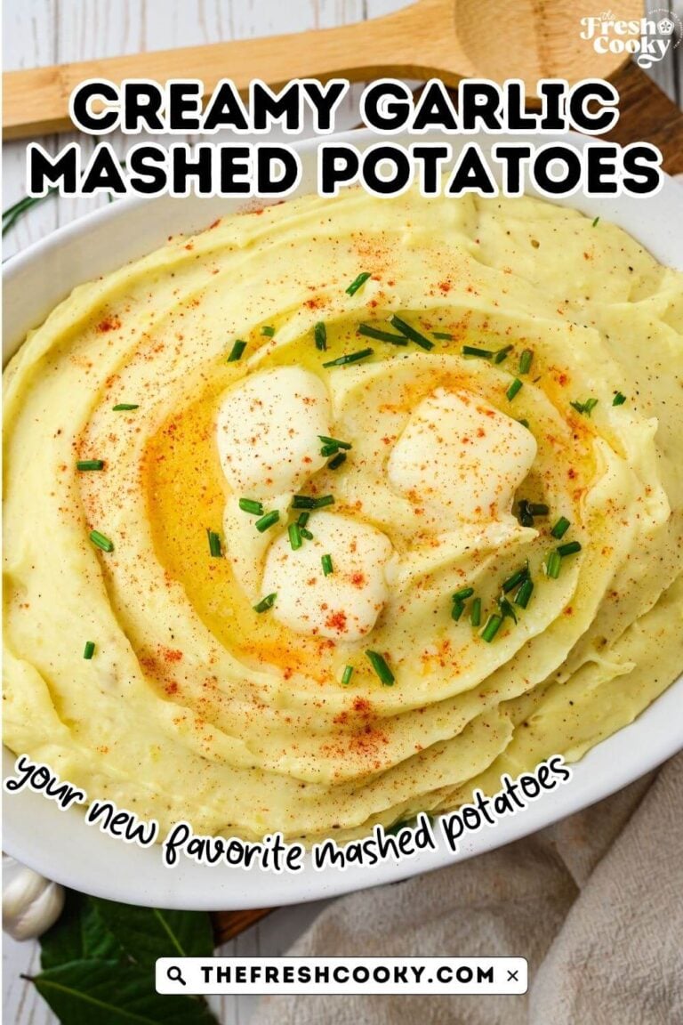 White casserole dish filled with creamy garlic mashed potatoes topped with melting pats of butter, chives and smoked paprika. To pin.