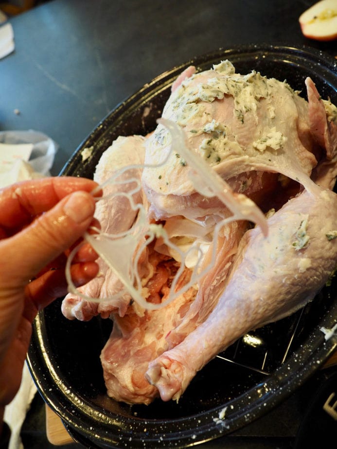 Removing plastic piece that holds the legs and tail together on turkey. Tender Turkey | www.thefreshcooky.com