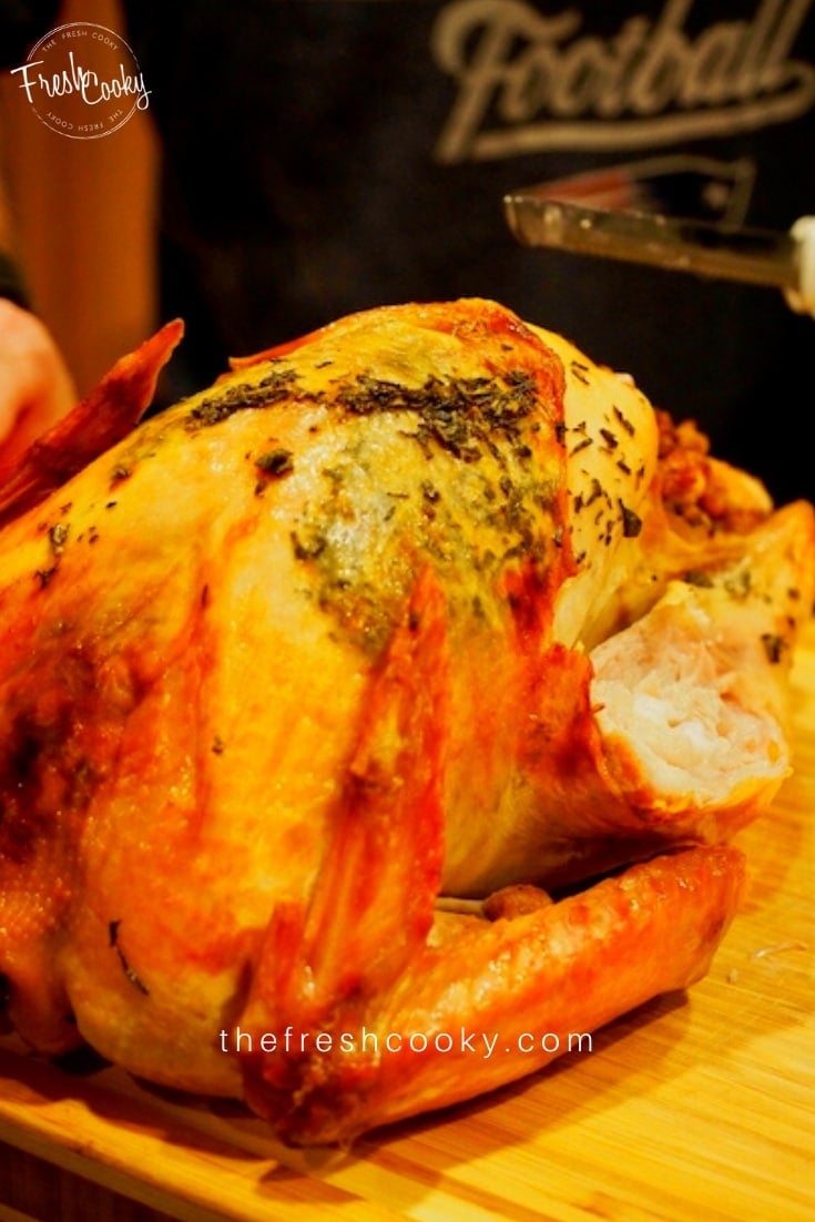 Roasted turkey with leg coming off, on a cutting board. 