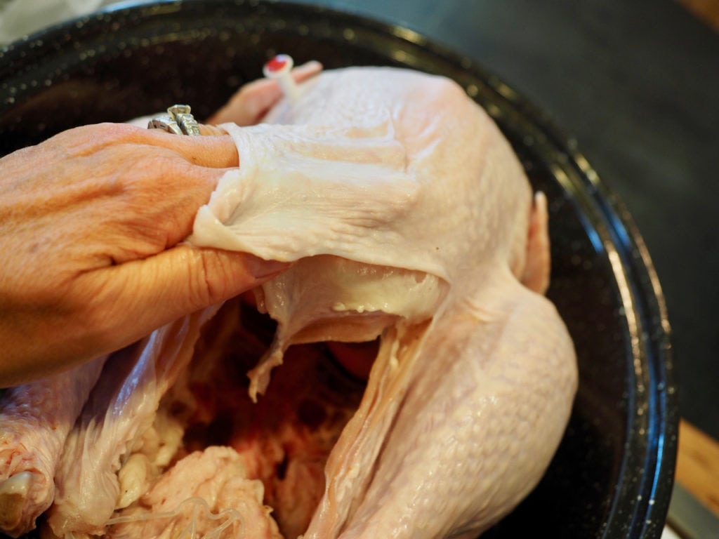 Using fingers to separate skin from breast meat on turkey then Tender Turkey | www.thefreshcooky.com