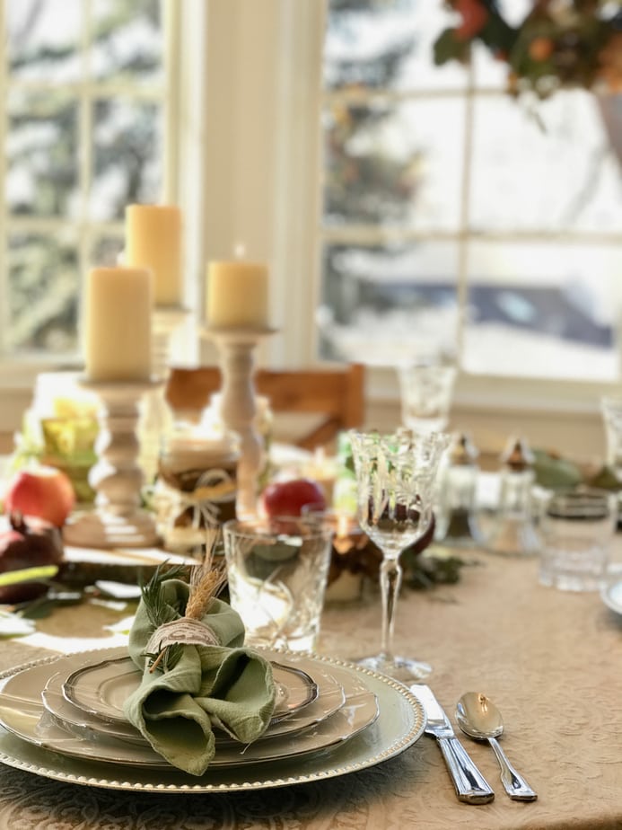 Image of all natural fall or Thanksgiving tablescape set with chargers, silverware, china and stemware. 