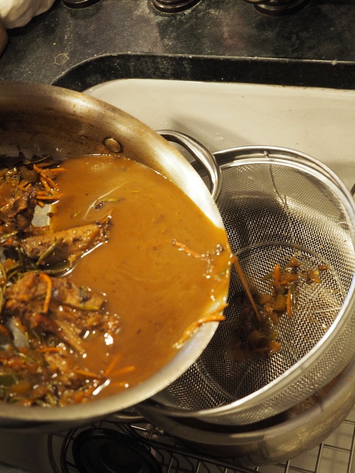 straining simmered gravy base through strainer into pot. 