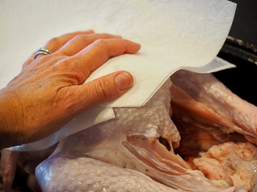 Drying with paper towels the uncooked whole turkey. Tender Turkey | www.thefreshcooky.com