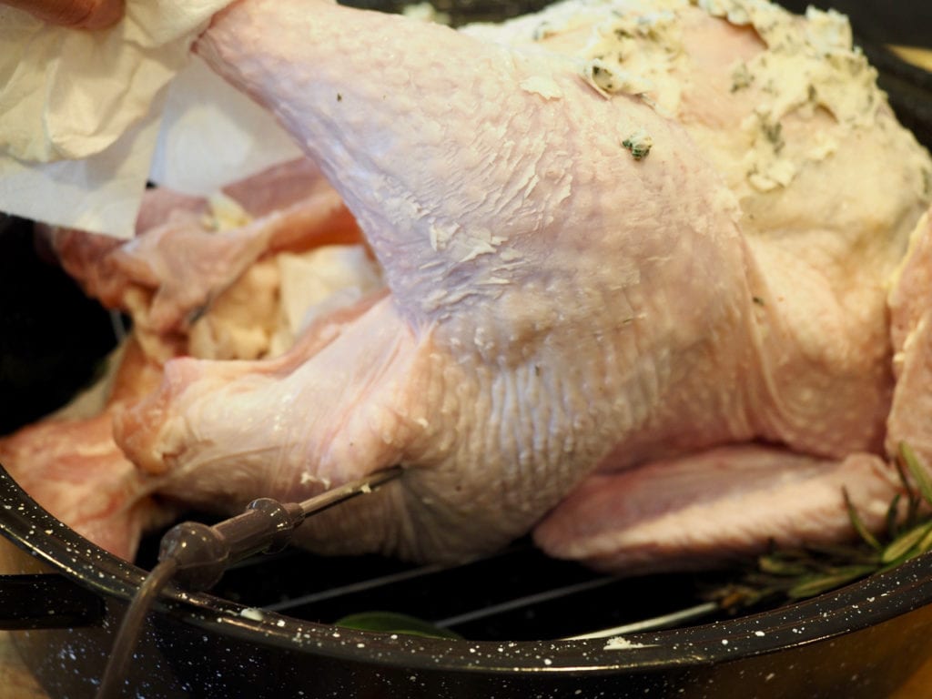 Inserting a thermometer probe into turkey thigh. Tender Turkey | www.thefreshcooky.com