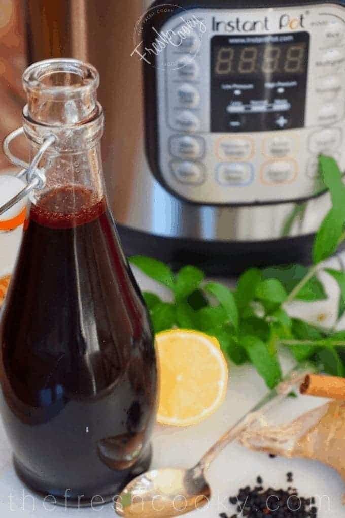 bottle of elderberry syrup with instant pot in background | via @thefreshcooky