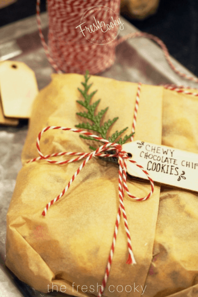 Cookie dough packaged in parchment with a wooden sign. 