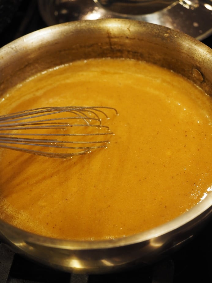 Whisking turkey giblet gravy to thicken in pan. 