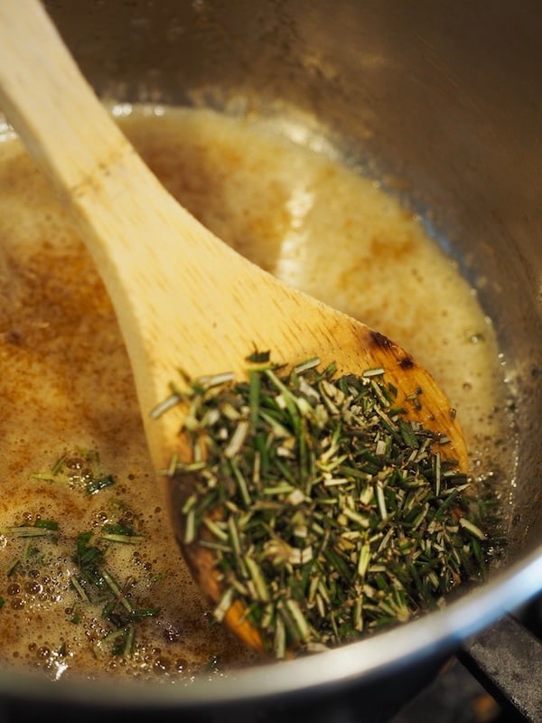 Adding fresh chopped rosemary to butter, sugar slurry for rosemary cashews.