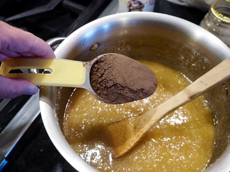 Adding dark cocoa powder to brownie mixture