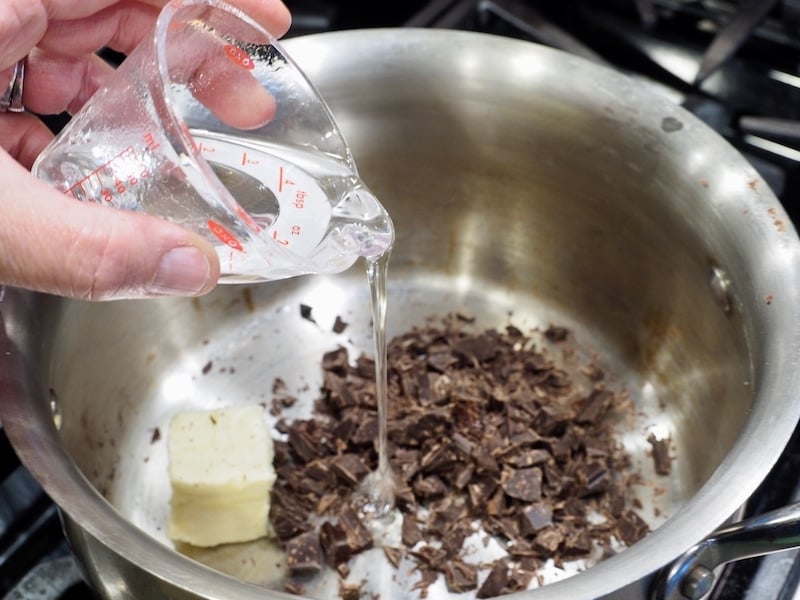 Adding a small amount of all natural corn syrup in a mini measuring cup to chopped chocolate, butter in a small saucepan for old fashioned hot fudge sauce.