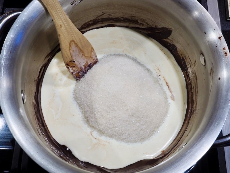 Natural cane sugar in cream and chocolate in small saucepan for chocolate sauce for ice cream. 