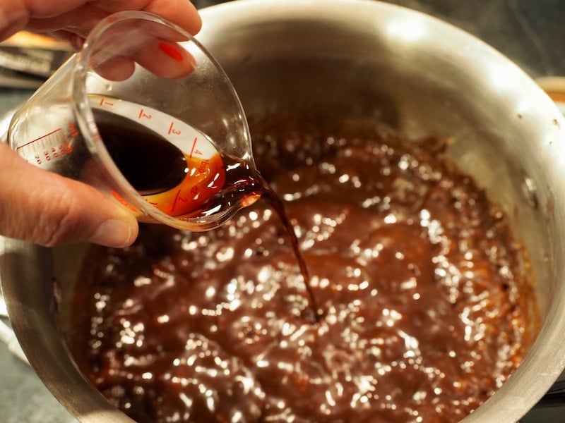 Pouring in using mini measuring cup pure vanilla extract.  