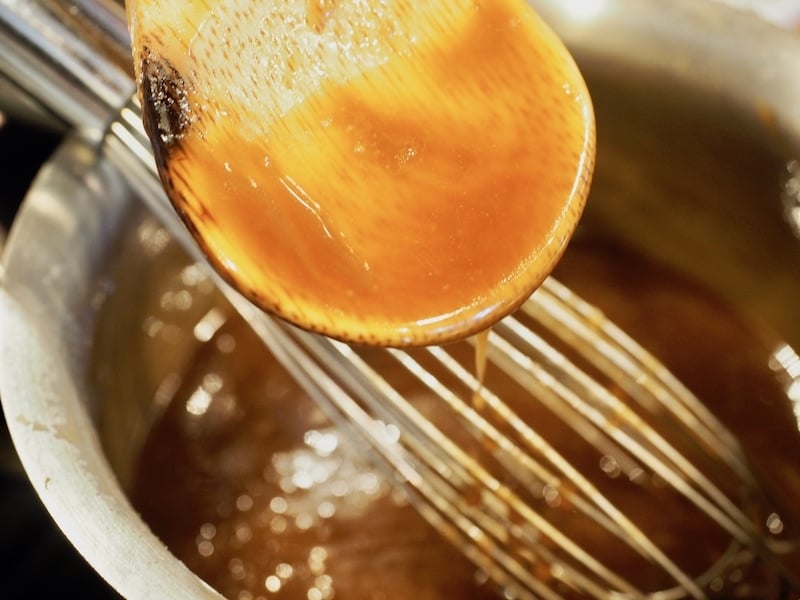 Wooden spoon with thick caramel on it/