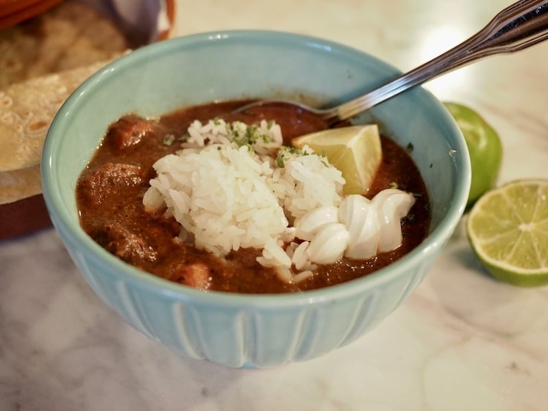 This thick, satisfying, hearty Black Bean & Sausage soup is a meal in itself; loaded with black beans, kielbasa, spices and blended until smooth, then topped with rice, lime, Mexican crema, cheese and cilantro. Easily convert to vegetarian by omitting the sausage and swapping veggie broth. #thefreshcooky #soup #blackbeansoup #vegetarian #kielbasa #sausage #kidfriendly