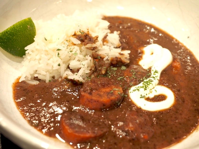 This thick, satisfying, hearty Black Bean & Sausage soup is a meal in itself; loaded with black beans, kielbasa, spices and blended until smooth, then topped with rice, lime, Mexican crema, cheese and cilantro. Easily convert to vegetarian by omitting the sausage and swapping veggie broth. #thefreshcooky #soup #blackbeansoup #vegetarian #kielbasa #sausage #kidfriendly